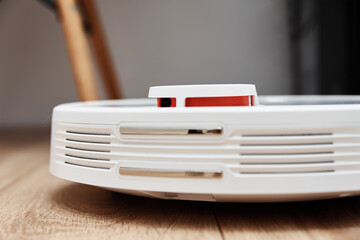 Robot vacuum cleaner working on floor with furniture, obstacles for robotic vacuum cleaner. Modern smart household