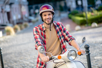 Naklejka premium Man wearing a red helmet riding a scooter