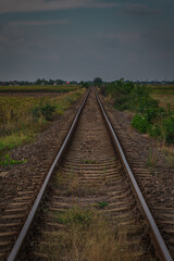 Fototapeta na wymiar Worn and bent railorad tracks between the fields in Romania. Poor shape of railway tracks through the fields.
