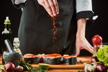 Chef seasoning raw salmon steaks. Gourmet dish, culinary