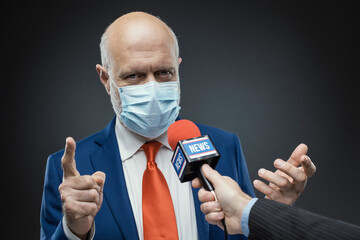 Politician doing an interview and wearing a surgical mask