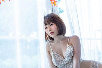 Portrait of young pretty sexy Asian woman wearing white bikini in her room. - obrazy, fototapety, plakaty
