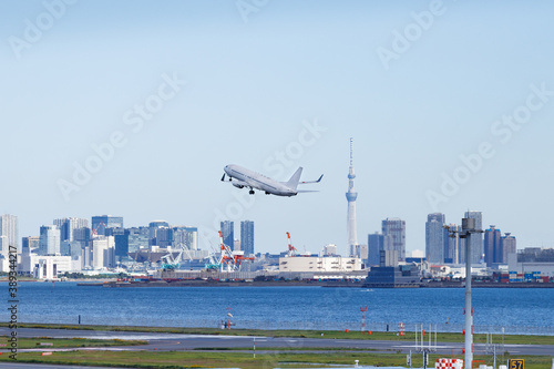 青空を背景に羽田空港を離陸する飛行機と東京湾岸のビル群とスカイツリー Wall Mural Maruboland 青空を背景に羽田空港を離陸する飛行機と東京湾岸のビル群とスカイツリー Wall Mural Maruboland