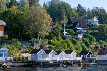 Fototapeta na wymiar Many small houses on hillside with lots of trees. Seaside, fishing