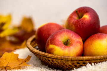 Colourful autumn apples and leaves in a basket 