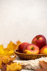 Colourful autumn apples and leaves in a basket 