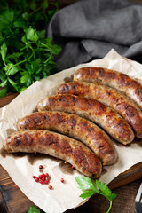 Fried sausages. Grilled sausages with spices on a wooden serving Board. Delicious meat sausages