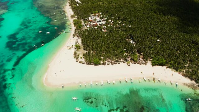 Seascape with beautiful beach and tropical island palm trees by coral reef from above. Daco island, Philippines. Summer and travel vacation concept