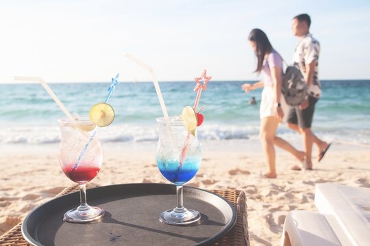 Summer drinks with lovers walking on the beach on background, vacation holiday concept