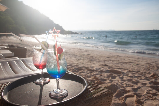 Summer drinks on table and the beach on background, vacation holiday concept
