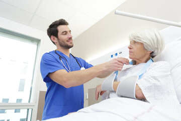 Obraz premium senior woman lying on bed receiving health care at home