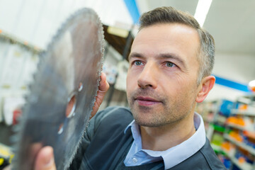 man buying a circular blade in a hardware store