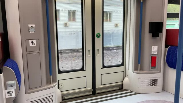 Interior of modern train of the Moscow Central diameter MCD. View to the doors in moving train.