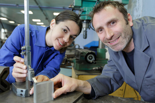 steel factory apprentice and instructor smiling