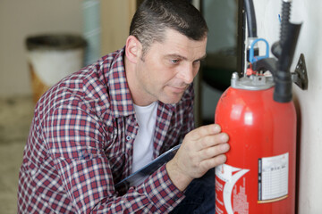 man inspecting the fire extinguisher