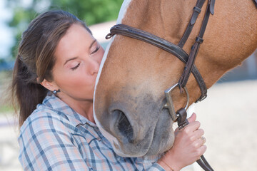 a female rider kissing her horse