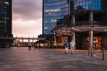 People walking during sunset in Gae Aulenti square, in the new Porta Nuova district in Milan