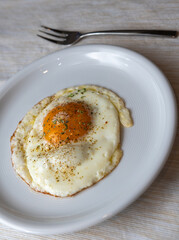 Gebratenes Ei - Spiegelei mit Kräuter auf Teller zum Frühstück