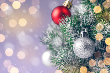 Christmas tree decorated with silver and red balls toys on a blurred, sparkling and fabulous fairy background with beautiful bokeh