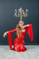 beautiful girl in a red ethnic dress dancing oriental dances