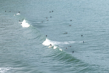 surfers surfing big waves on the coast of Cantabria at the Playa de Luana Beach in Cobreces