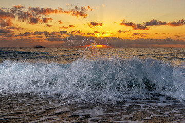 Fototapeta na wymiar Beautiful clouds over the sea, sunrise and splashing waves.