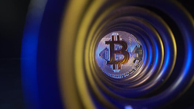 Gold coin Bitcoin with beautiful blue and yellow light in the ind of tunnel. Glass surface. Blockchain trading technology. Mining. New currency. Popular cryptocoin.