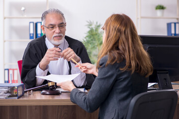 Old male judge and female client in the office
