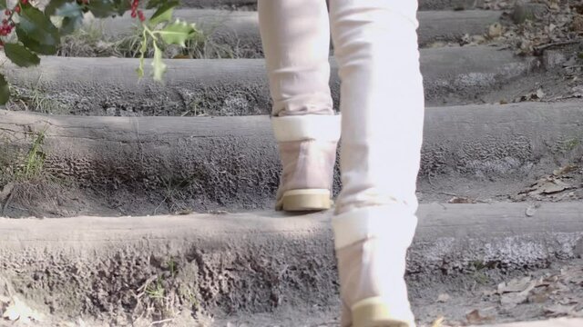 Walking view woman haking up the wood steps on a path in the forest. Slow motion 4K