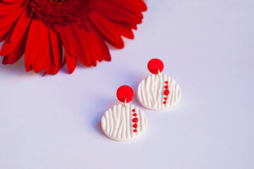 Red white earrings with red flower. Fashion jewelry background.