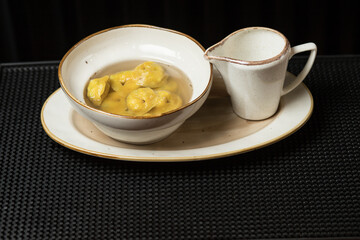 Fresh and hot dumplings with bouillon. Isolated delicious on white dishes