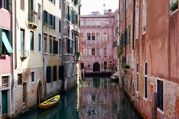 Fototapeta na wymiar Bunter Kanal in Venedig im Sommer mit einem gelben Boot, Italien
