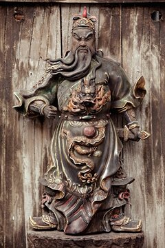 Wooden carving of an ancient chinese warrior, king's general, on a wooden door (with a dragon holding a pearl - from folk stories).