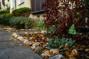 Garden gnome decoration with autumn leaves in the garden