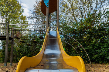 Metal children's slide in autumn on a playground