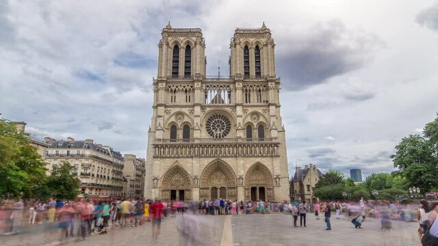 Front view of Notre-Dame de Paris timelapse hyperlapse is a medieval Catholic cathedral on the Cite Island in Paris, France. Long queue of tourists. Cloudy sky at summer day