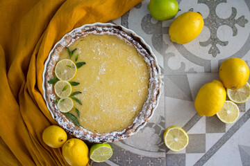 Lemon tart on grey tiled kitchen table.  Homemade dessert top view photo. 
