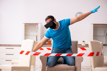 Young man enjoying virtual glasses at home during pandemic