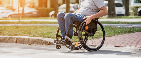Handicapped man in wheelchair crossing street road