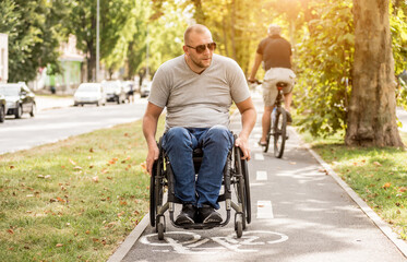 Handicapped man in wheelchair walk at the park alley