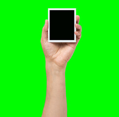 Man holding blank instant photo against a green background with copy space.