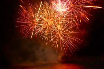 Red colorful fireworks on the black sky background. Holiday celebration