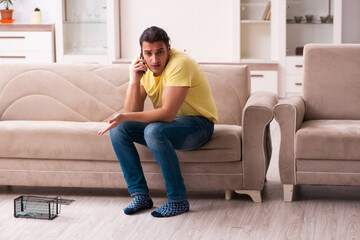Obraz premium Young man and mousetrap at home