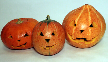 Pumpkins with carved faces on a white background