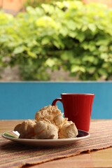 Breakfast, with starch biscuit, cheese bread, served on a wooden table outdoors. Farm breakfast. Coffee, coffee strainer on the table.