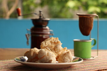 Breakfast, with starch biscuit, cheese bread, served on a wooden table outdoors. Farm breakfast. Coffee, coffee strainer on the table.