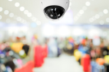 Modern public CCTV camera with blur interior shopping mall background. Recording cameras for monitoring all day and night. Concept of surveillance and monitoring with copy space.