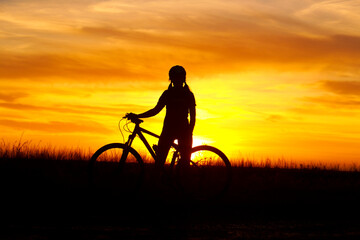 silhouette of a person with a bicycle