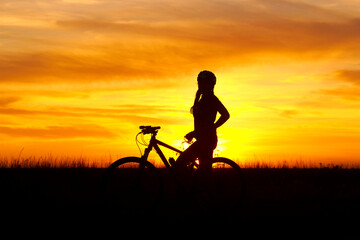 silhouette of a person with a bicycle