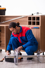 Young handsome male carpenter working indoors